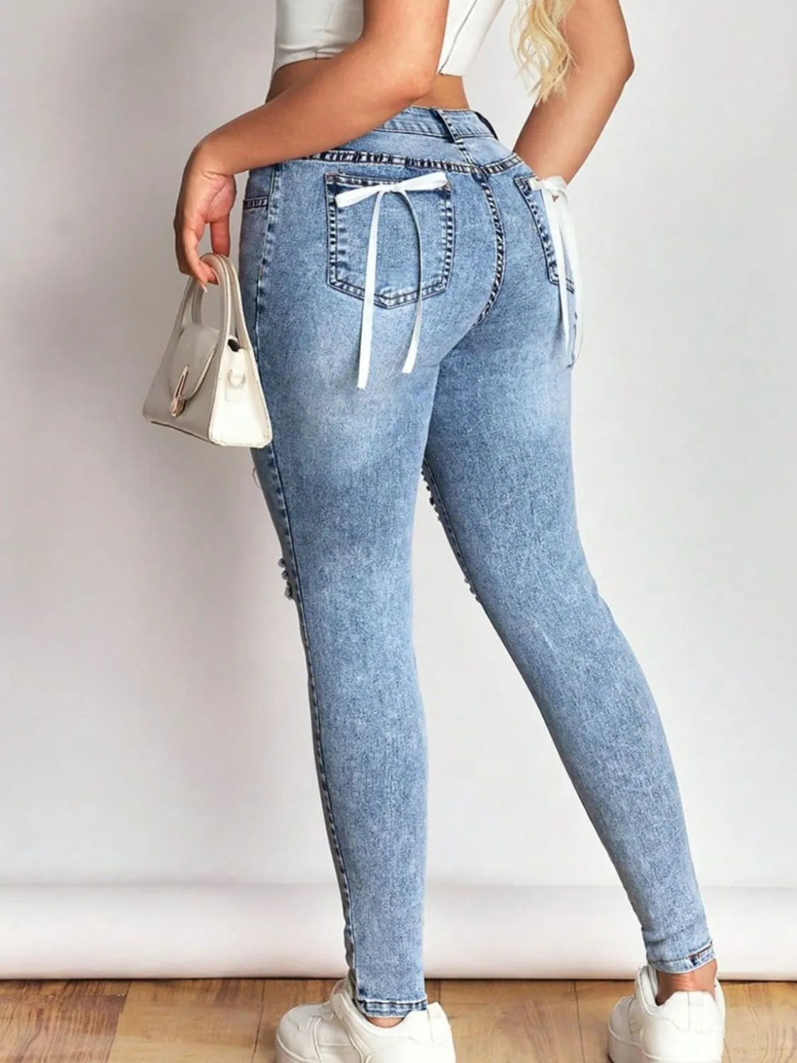 distressed skinny jeans with bow back