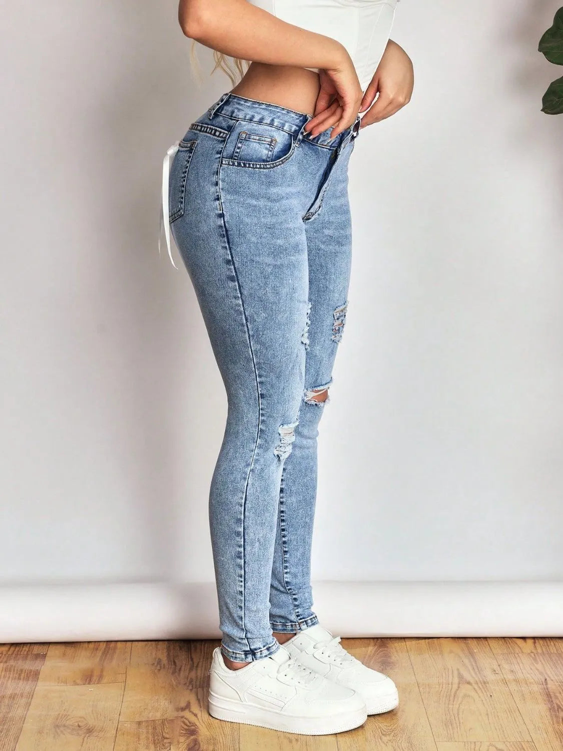 distressed skinny jeans with bow back