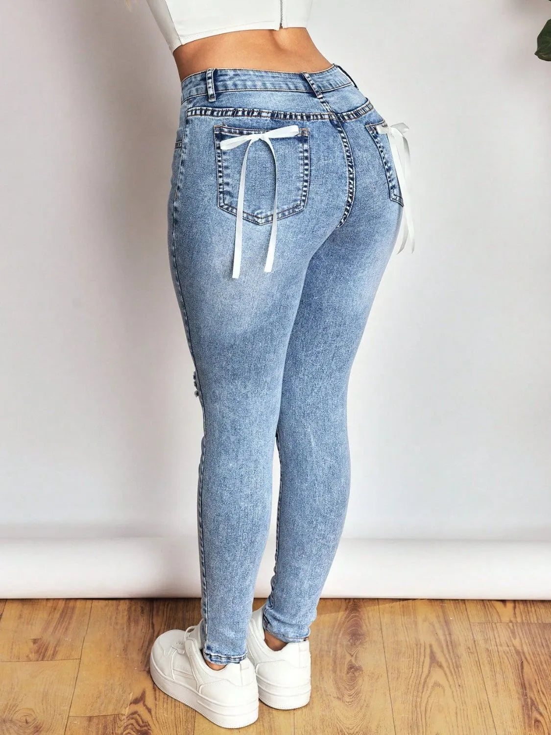 distressed skinny jeans with bow back